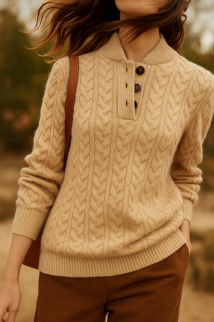 Femme en pull beige à torsades épaisses et col boutonné, sac en cuir à l'épaule, une main dans la poche. 10