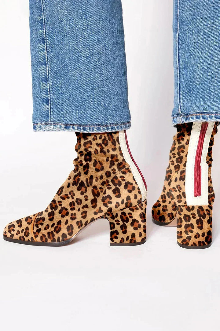 Bottines à imprimé léopard portées avec un jean, avec zip rouge sur bande blanche à l'arrière. 4
