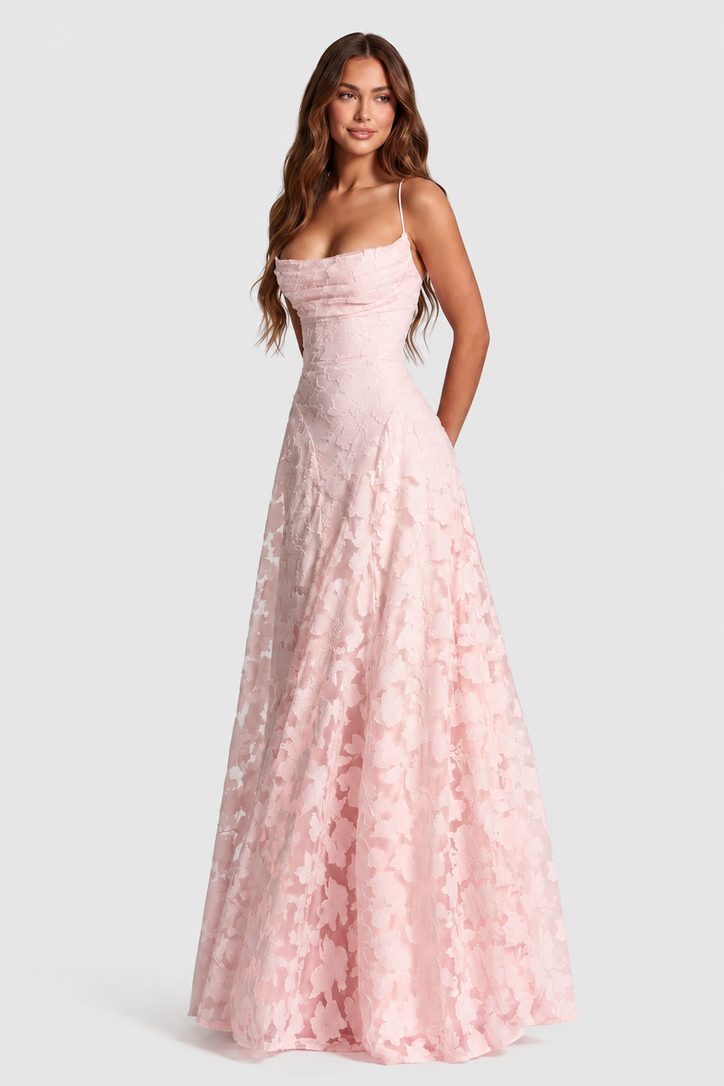 Robe rose pâle en dentelle florale en relief, encolure drapée et jupe évasée transparente, portée de face par une mannequin. 18