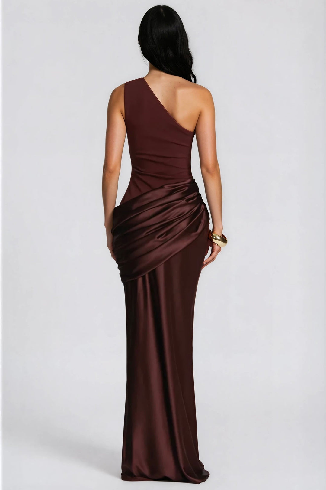 Robe bordeaux foncé vue de dos, avec la bretelle asymétrique, le drapé en satin et un bracelet doré. 7