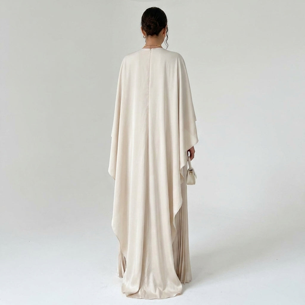 Robe beige vue de dos, large cape fluide tombant sur la jupe plissée 3