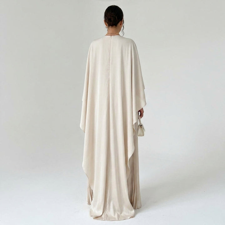 Robe beige vue de dos, large cape fluide tombant sur la jupe plissée 3