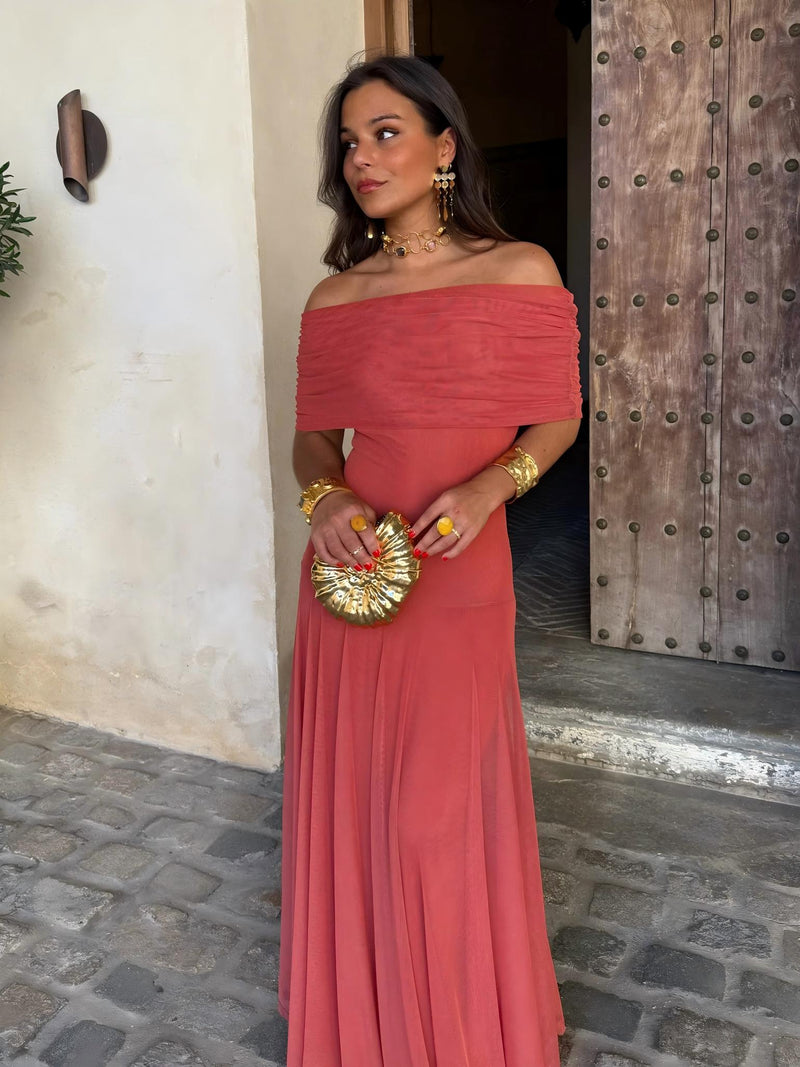 Robe corail à épaules dénudées, buste drapé, portée de face avec une pochette coquillage dorée 7