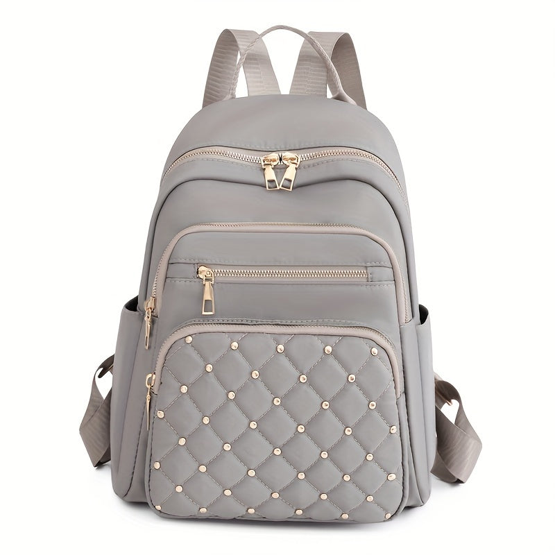Sac à dos gris clair vu de face, poche avant matelassée avec clous dorés 14