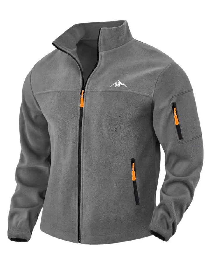 Vue de face en trois quarts de la veste polaire gris foncé, zip noir et tirettes orange 6
