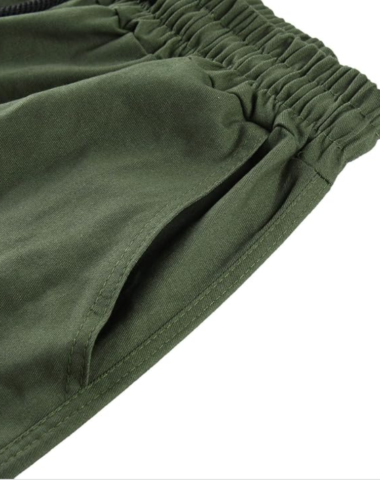 Gros plan sur la taille élastiquée et la poche latérale du pantalon vert olive, avec surpiqûres visibles. 13