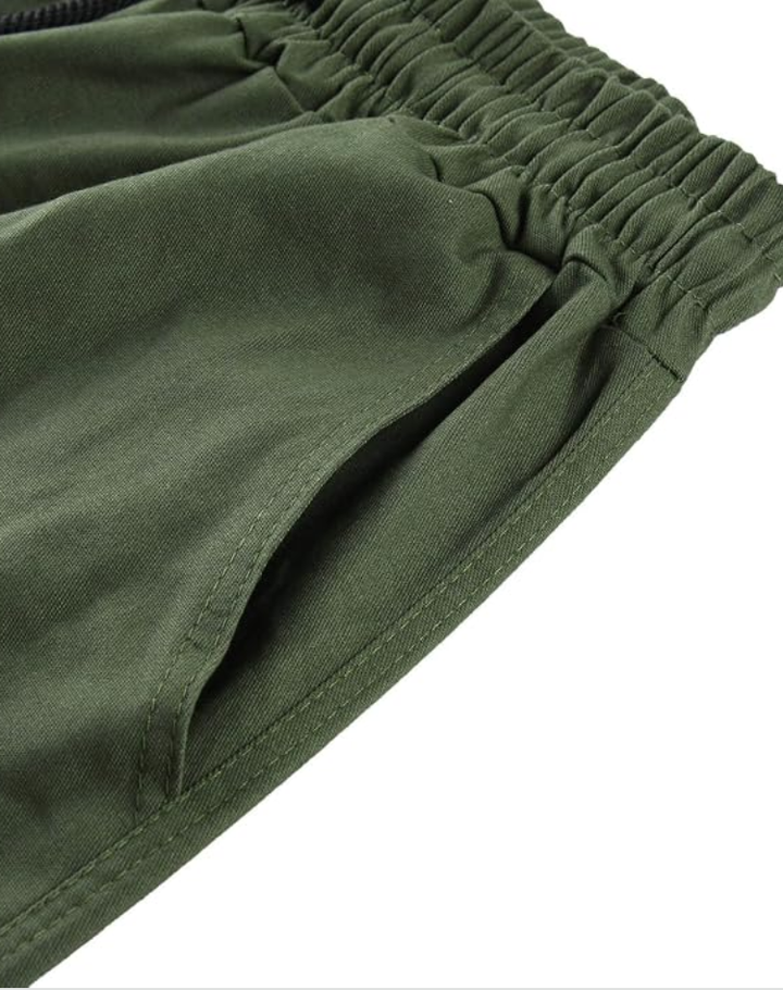 Gros plan sur la taille élastiquée et la poche latérale du pantalon vert olive, avec surpiqûres visibles. 13