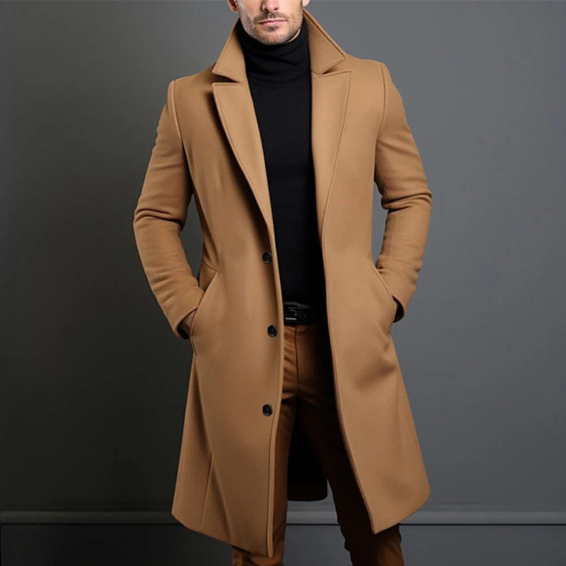 Même manteau long en version camel, porté par un homme les mains dans les poches, avec col roulé noir. 2