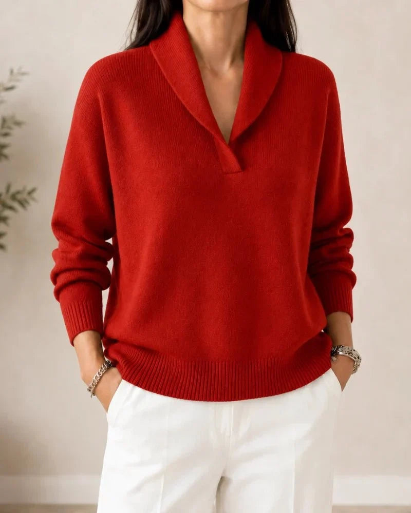 Pull porté de face en coloris rouge brique, avec pantalon blanc, col châle et poignets côtelés. 10