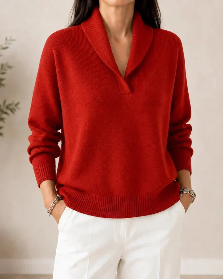 Pull porté de face en coloris rouge brique, avec pantalon blanc, col châle et poignets côtelés. 10