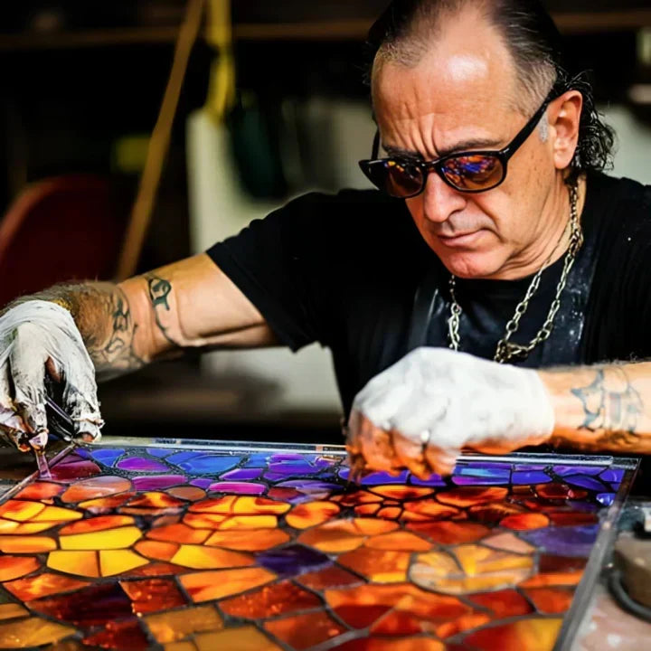 Artisan tatoué en lunettes de soleil assemblant à la main un panneau de verre coloré 2