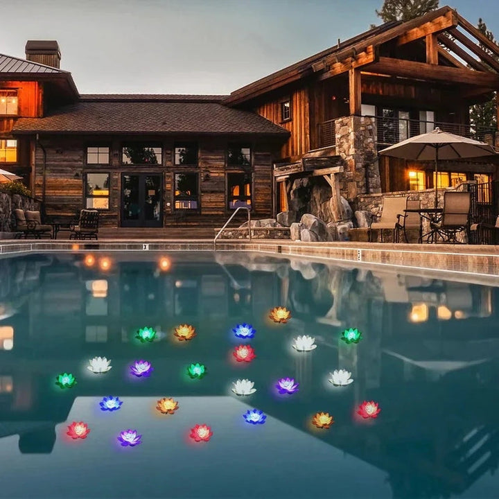 Nombreux lotus lumineux multicolores flottant sur une piscine devant une maison en bois au crépuscule 7