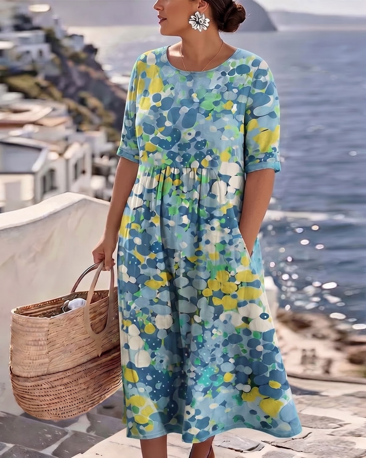 Robe bleue à motif floral portée par un mannequin en grande taille, fronces sous la poitrine, main dans la poche 10