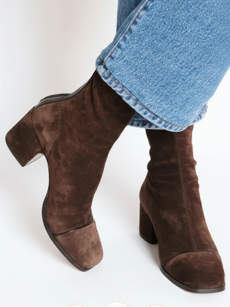Bottines en daim marron à talon carré et bout rapporté, portées avec un jean bleu, vues de trois quarts. 1