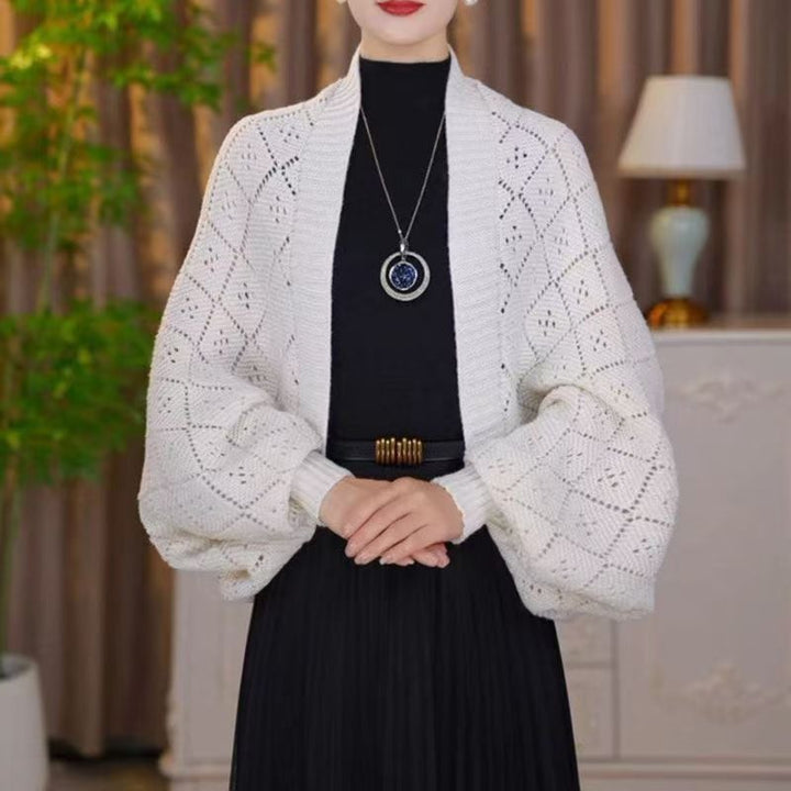 Cardigan ajouré blanc crème porté par un mannequin, motifs en losanges ajourés bien visibles sur les manches 4