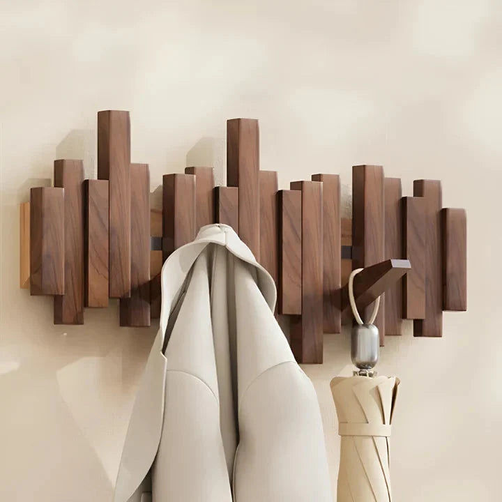 Portemanteau en bois foncé avec une veste beige et un parapluie fermé accrochés à deux crochets 8