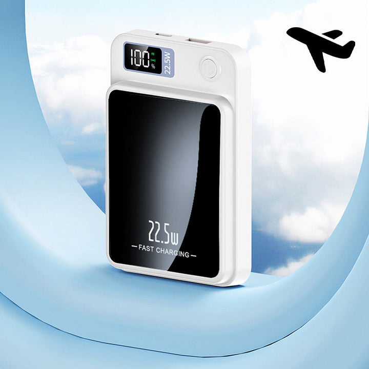 Chargeur blanc compact présenté devant un hublot d'avion sur fond de ciel nuageux, pour illustrer l'usage en voyage. 8