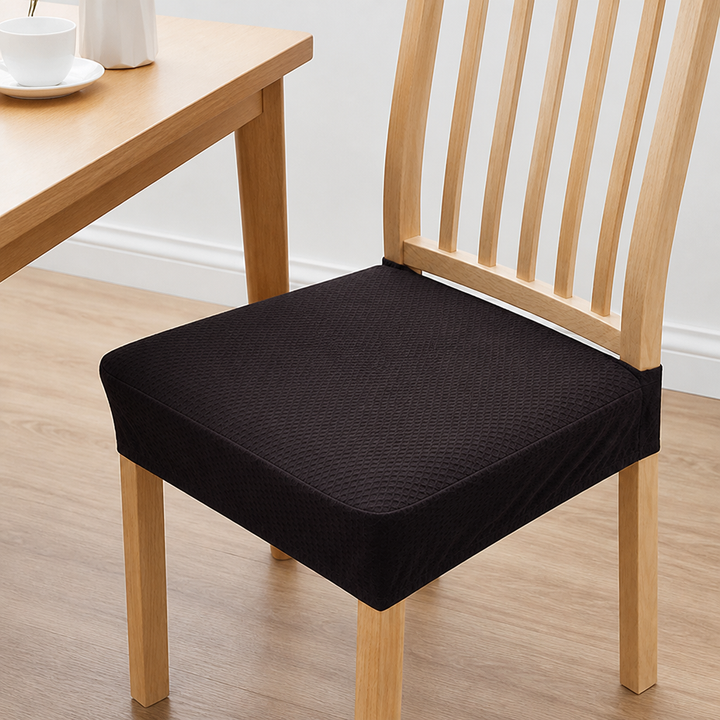 Housse d'assise brun très foncĂ© Ă  motif gaufrĂ© sur une chaise en bois clair, bord d'une table en bois visible Ă  gauche. 11