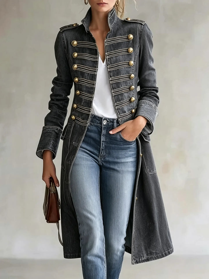 Manteau croisé à col officier en coloris gris anthracite, boutons dorés et galons, porté avec jean bleu et tee-shirt blanc. 10