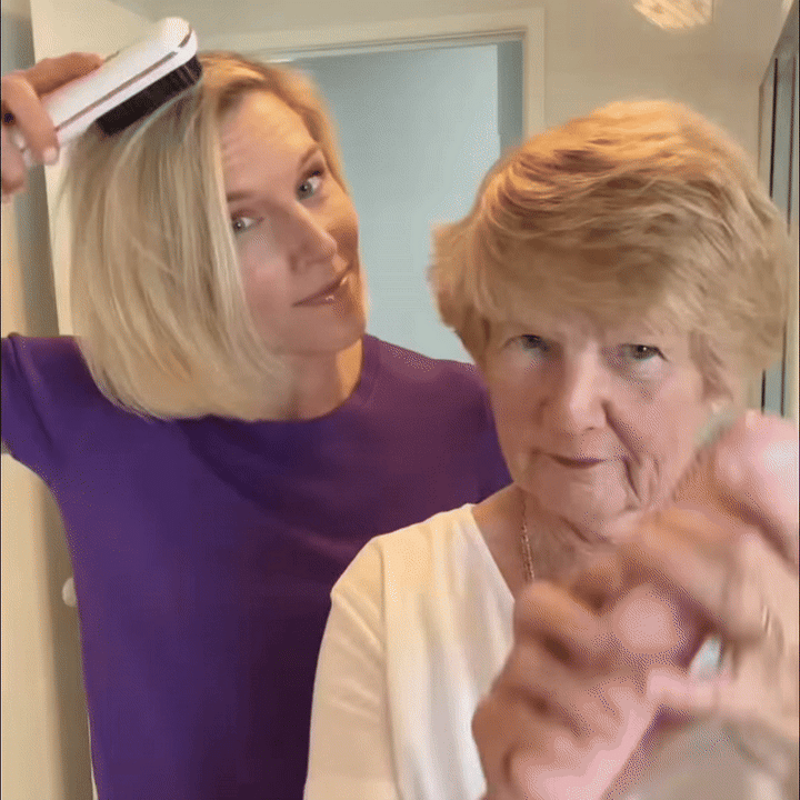 Femme en haut violet lissant ses cheveux blonds avec une brosse blanche à côté d'une femme âgée aux cheveux courts. 9