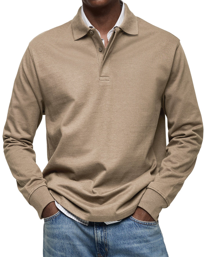 Polo à manches longues beige taupe porté par un homme, mains dans les poches, chemise rayée en dessous et jean délavé. 8