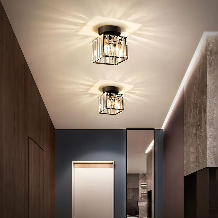 Deux plafonniers carrés en cristal à base noire allumés dans un couloir moderne aux murs de bois et de pierre. 7