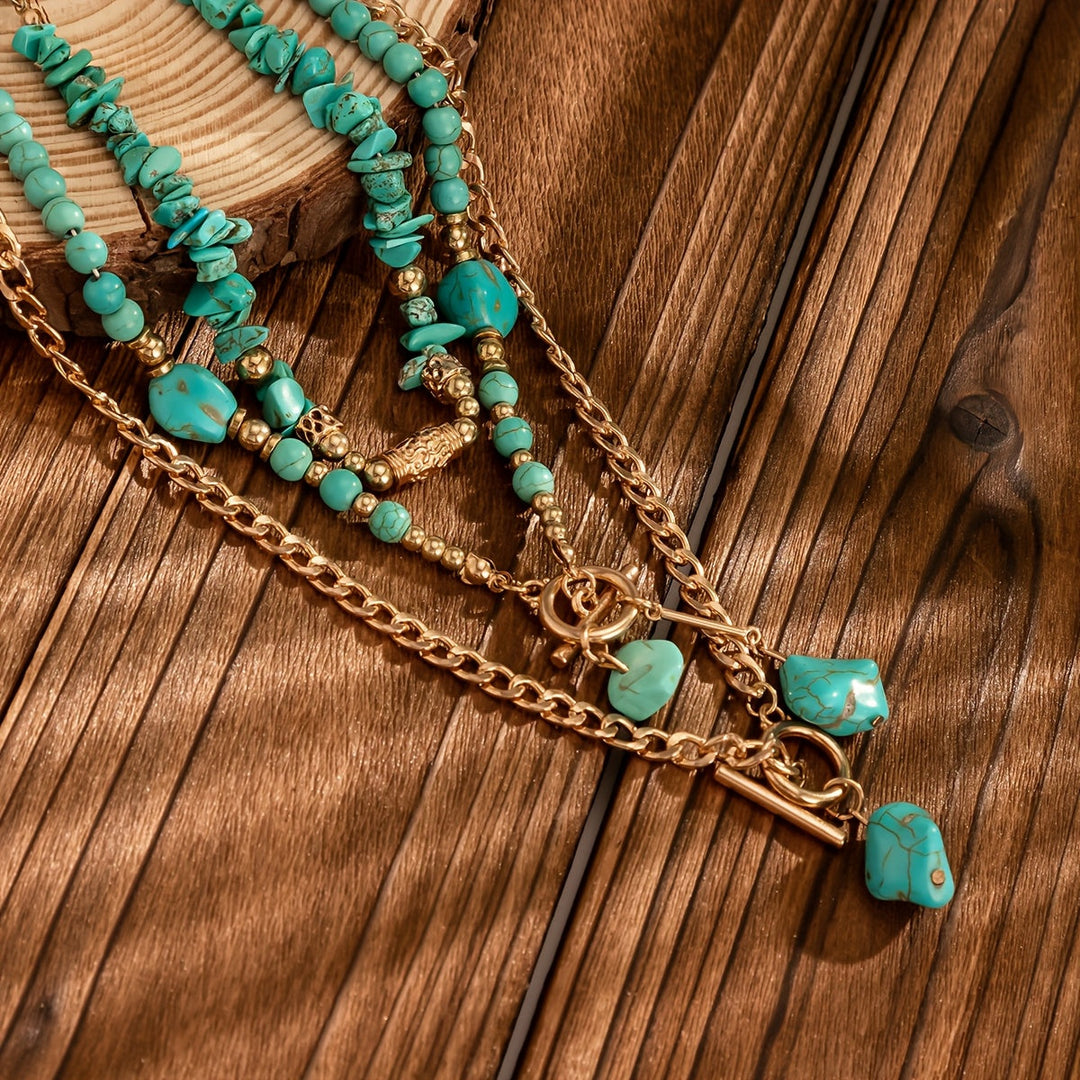Colliers turquoise et chaînes dorées posés sur une planche de bois, avec fermoirs à bascule et pierres pendantes 4