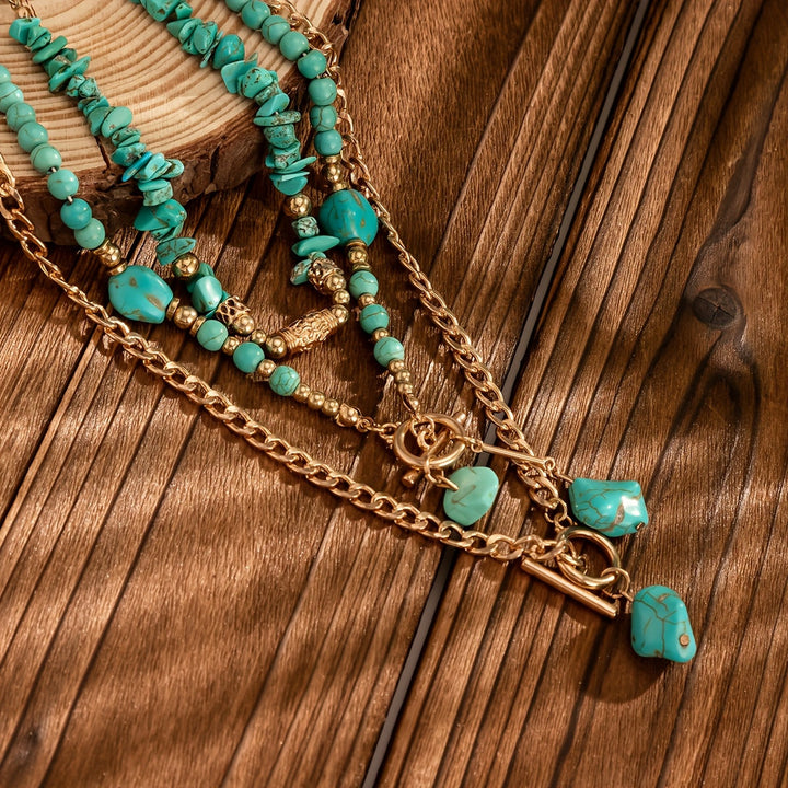 Colliers turquoise et chaînes dorées posés sur une planche de bois, avec fermoirs à bascule et pierres pendantes 4