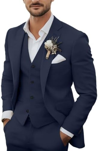 Homme portant le costume trois pièces en bleu marine, avec chemise blanche, boutonnière fleurie et pochette blanche, vu de face. 1