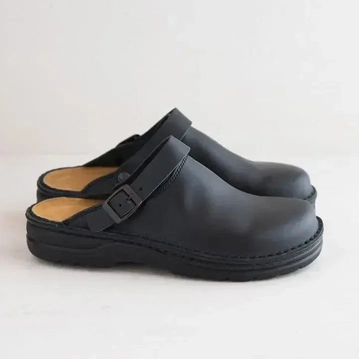 Profil d'une paire de mules noires avec bride à boucle et semelle intérieure beige 6