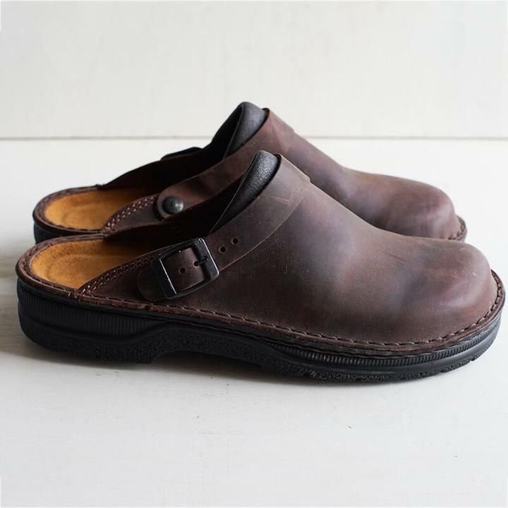 Profil d'une paire de mules en cuir brun foncé avec boucle et semelle intérieure beige 4
