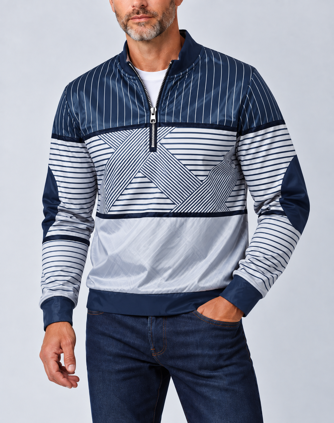 Homme barbu portant le pull bleu marine et blanc à demi-zip, col montant, sur un t-shirt blanc et un jean, vu de face. 1