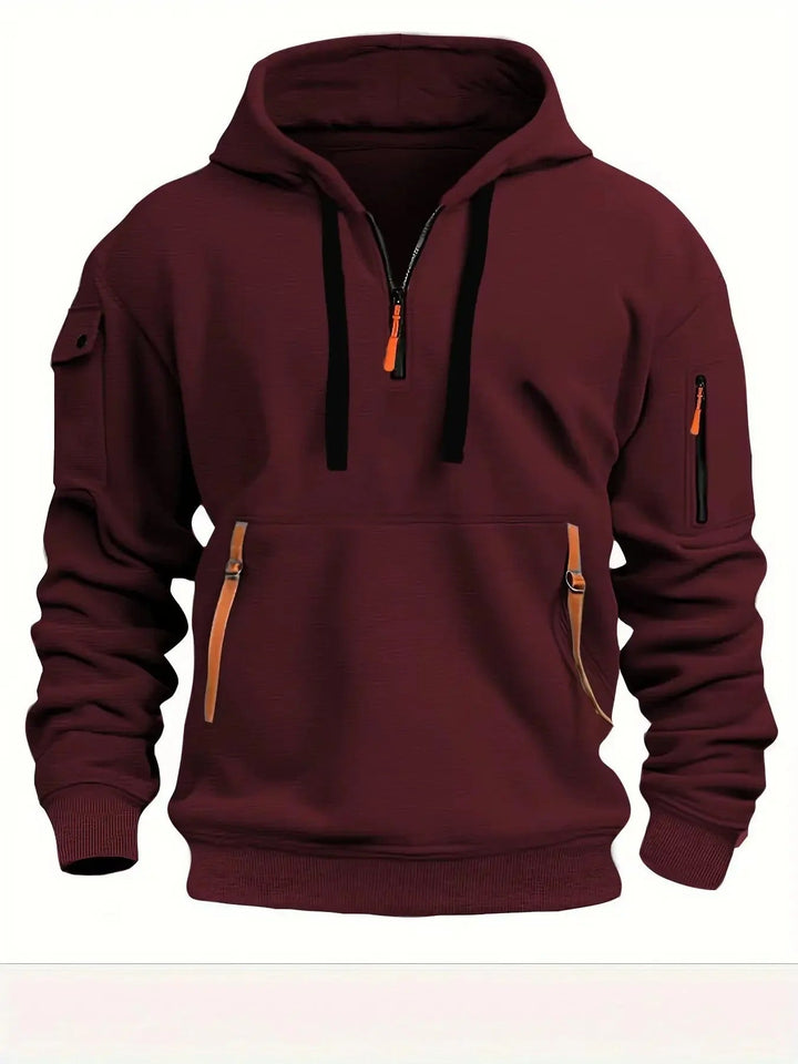 Vue de face du coloris bordeaux, avec cordons noirs, demi-zip orange et poches zippées bordées d'orange. 5