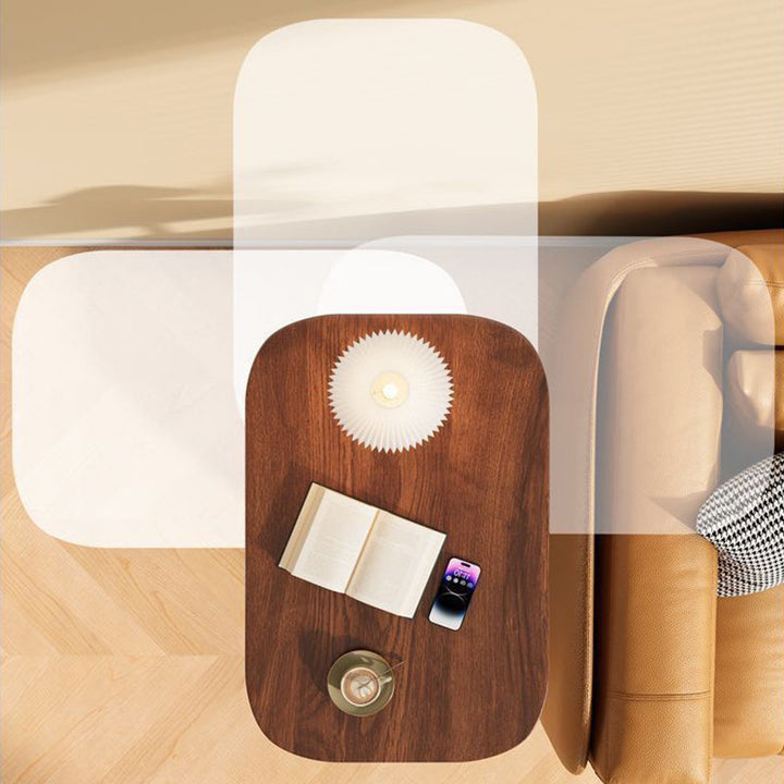 Vue de dessus du plateau en bois foncé portant lampe, livre ouvert, téléphone et tasse, superposée à ses positions pivotées près du canapé. 7