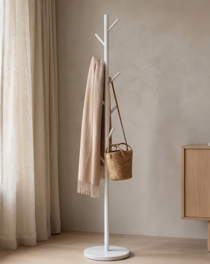 Version blanche du portant dans un salon, avec une écharpe beige et un petit panier en paille suspendus. 3