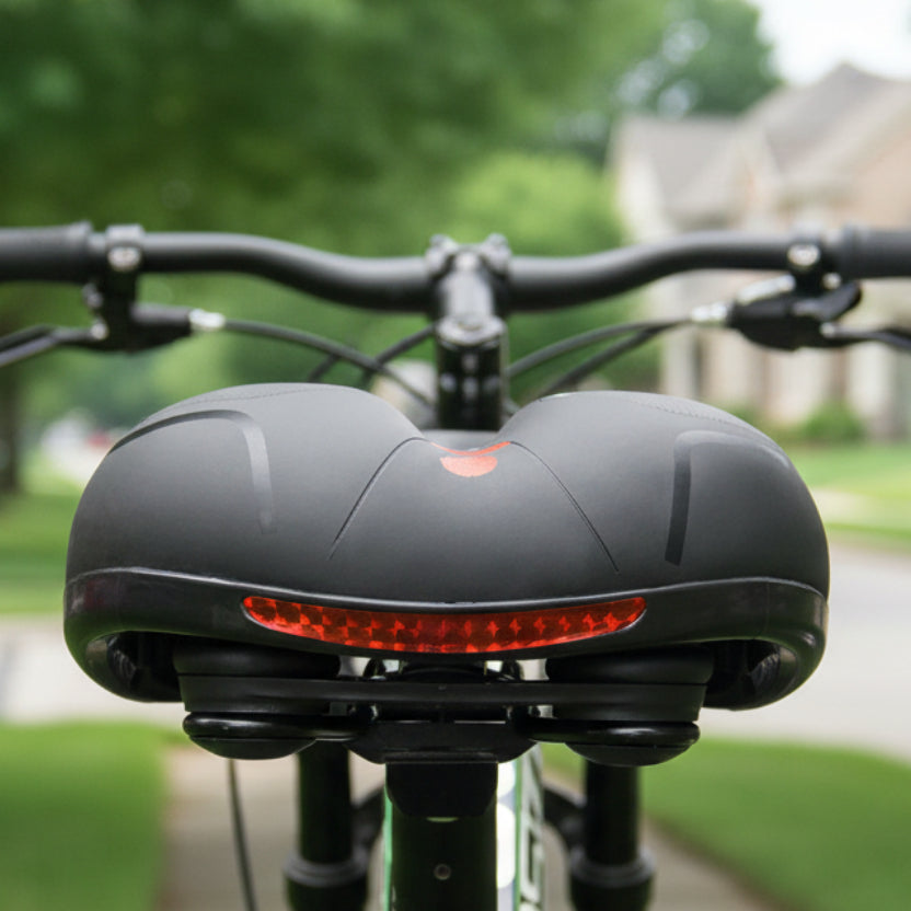 Vue arrière de la selle sur un vélo, avec sa bande réfléchissante rouge et ses doubles amortisseurs sous l'assise. 2