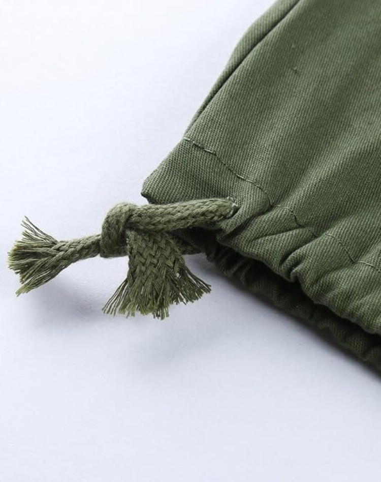 Gros plan sur le cordon de serrage noué au bas de la jambe du pantalon vert olive, avec ourlet froncé. 12
