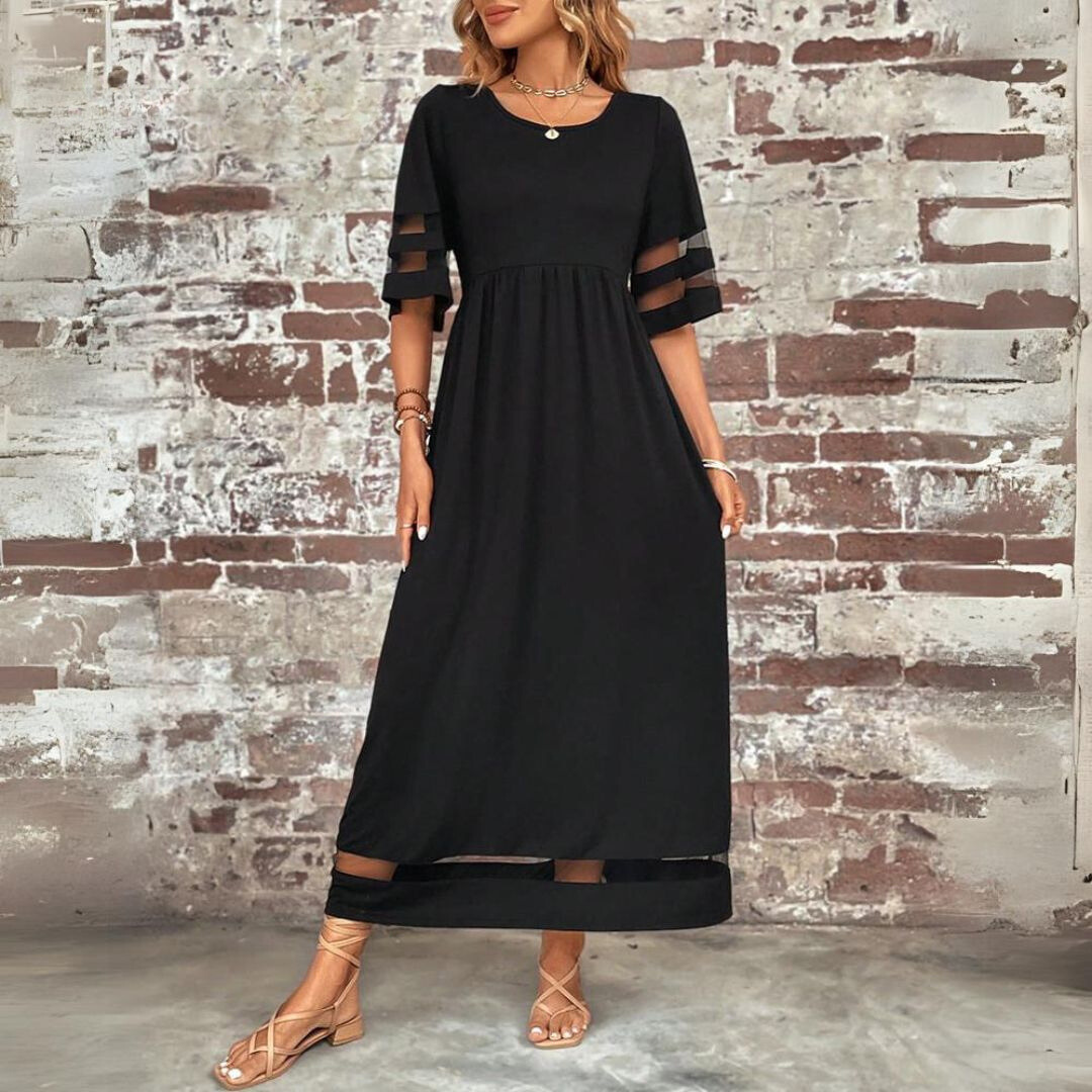 Robe longue noire portée de face, bras le long du corps, montrant l'encolure ronde, la taille haute et les manches évasées transparentes. 4