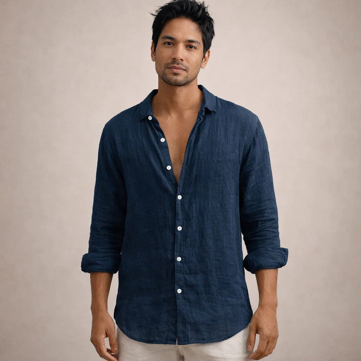 Homme portant la chemise en lin bleu marine avec poche poitrine, vue de face, manches retroussées, pantalon clair. 12