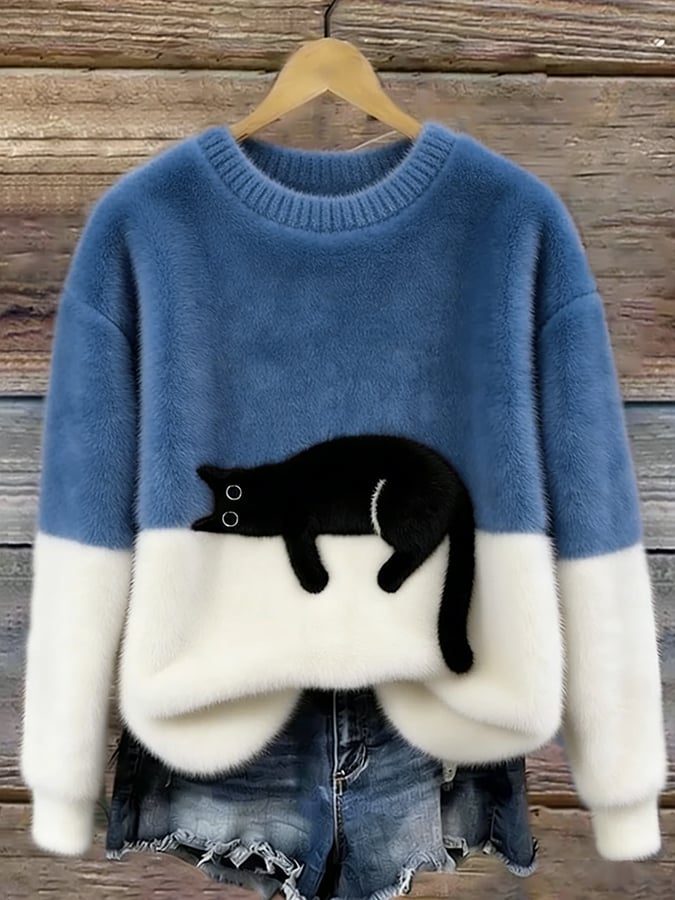 Pull duveteux bleu denim et blanc avec chat noir allongé, présenté sur cintre avec un short en jean 8