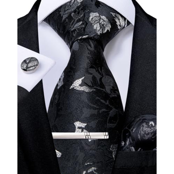 Cravate noire à feuillages gris argenté, avec pince, bouton de manchette et pochette assortis, portée avec veste noire et chemise blanche. 6