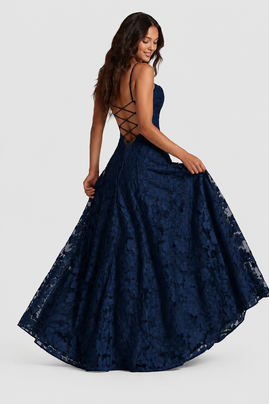 Robe bleu marine en dentelle florale vue de dos, laçage croisé dans le dos, mannequin en mouvement tenant le bas de la jupe. 5