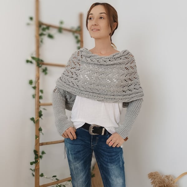 Châle gris clair porté de face avec manches intégrées, col drapé, t-shirt blanc, jean et ceinture noire. 8
