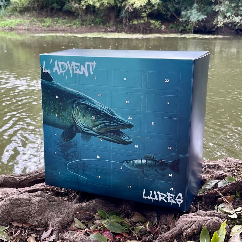 Boîte bleue à 24 cases numérotées ornée d'un brochet, posée sur des racines au bord d'une rivière 1