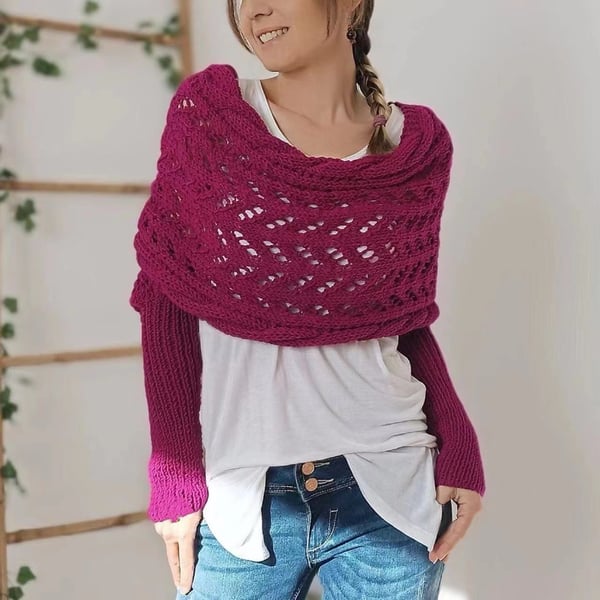 Femme souriante portant le châle ajouré fuchsia avec manches intégrées, sur un t-shirt blanc et un jean, vue de face. 21
