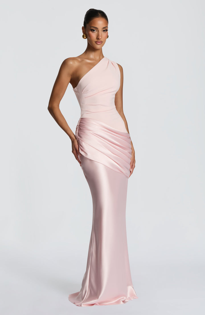 Robe rose pâle vue de trois quarts, buste en crêpe plissé, drapé satiné marqué et jupe longue brillante. 13