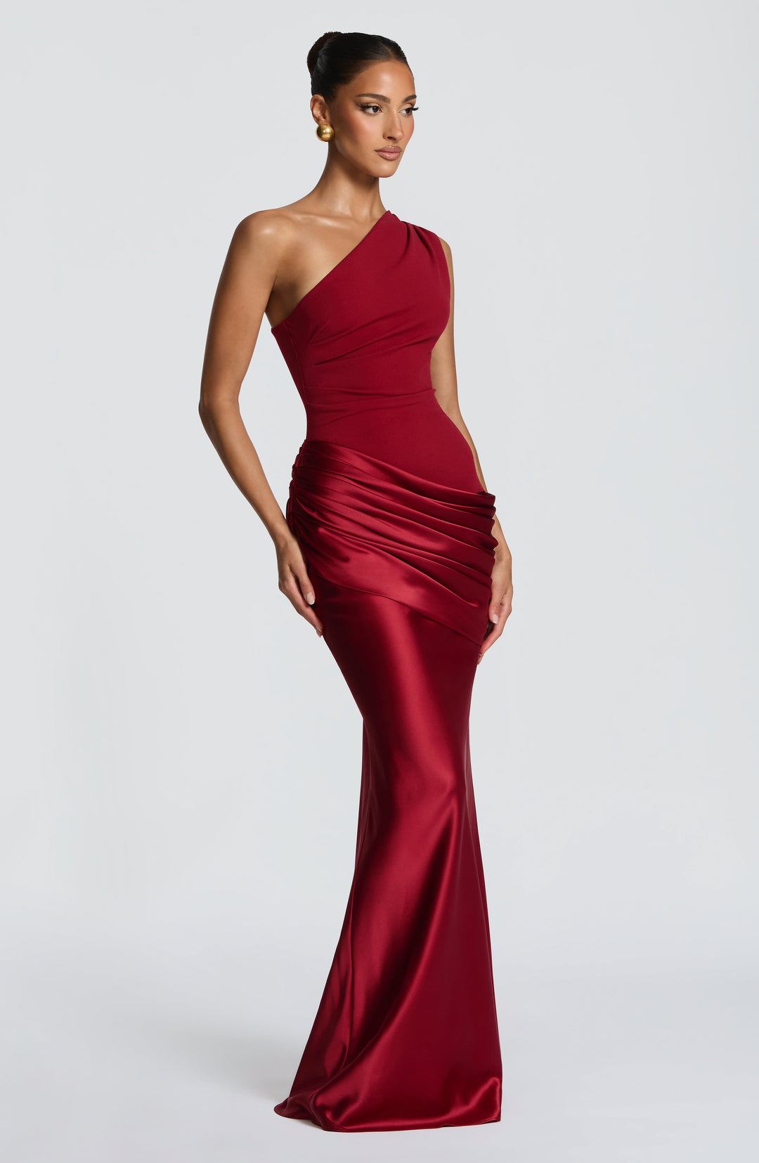 Robe rouge bordeaux vue de trois quarts, mannequin de profil, plis du drapé satiné et jupe évasée vers le bas. 16