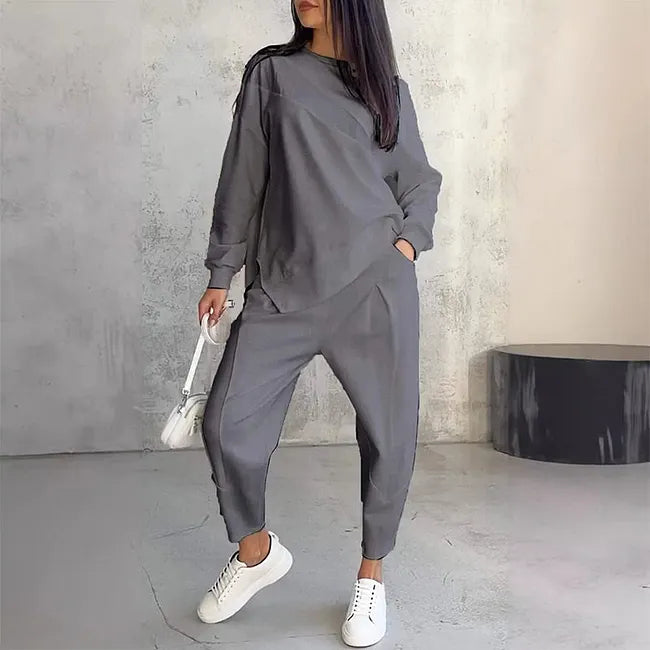Même ensemble en version grise, porté avec baskets blanches et petit sac blanc, une main dans la poche du pantalon. 3
