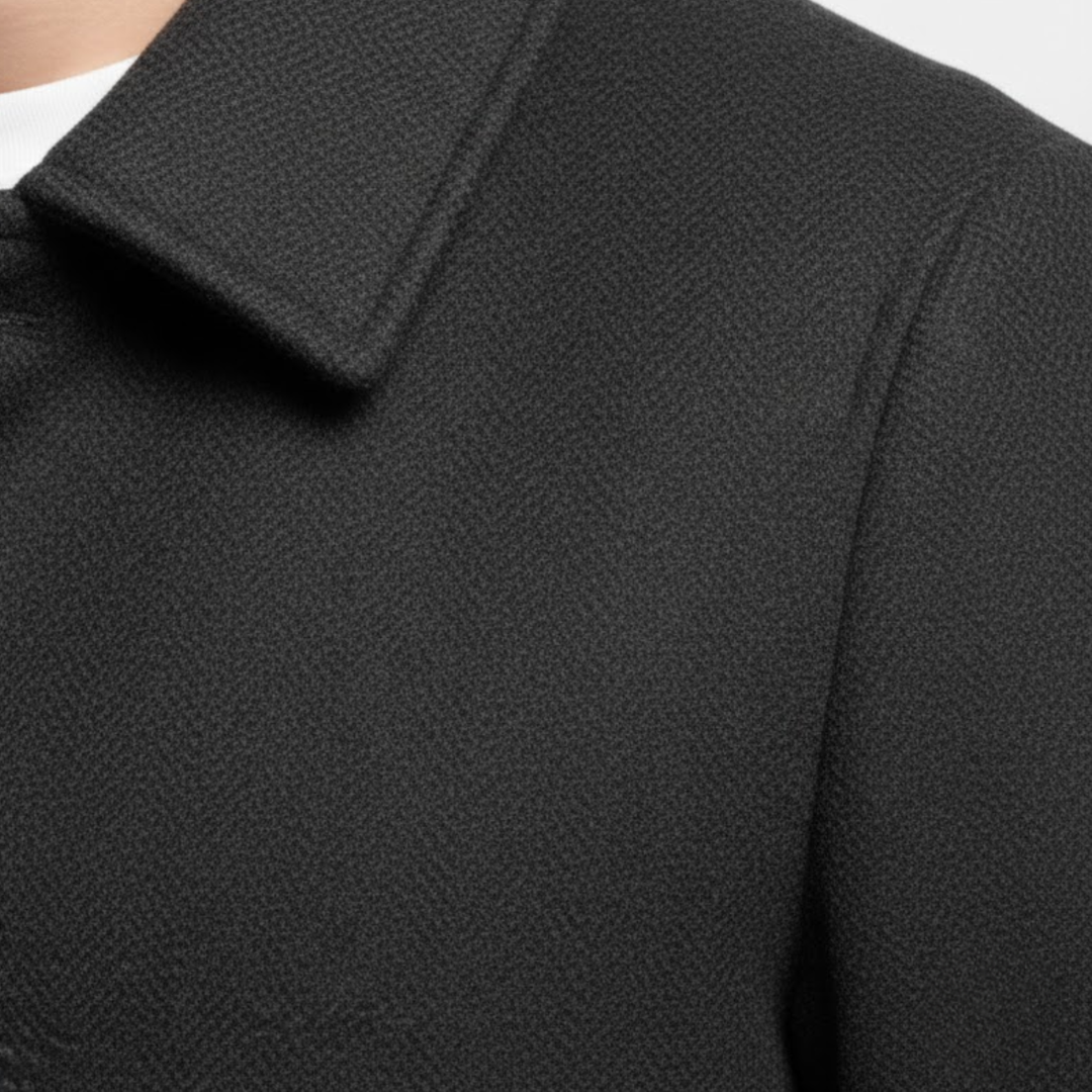 Gros plan sur le col à revers et l'épaule du manteau noir, texture du tissu 7