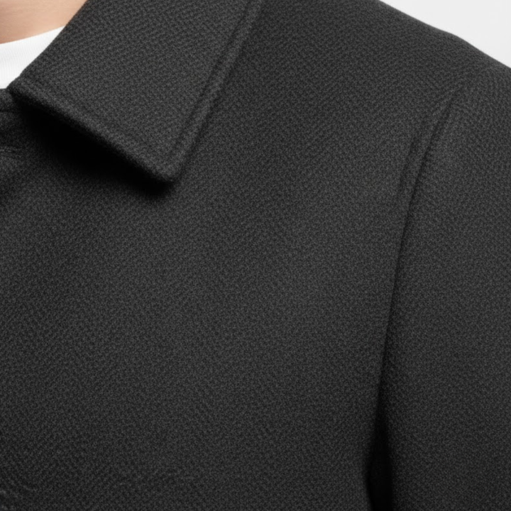 Gros plan sur le col à revers et l'épaule du manteau noir, texture du tissu 7